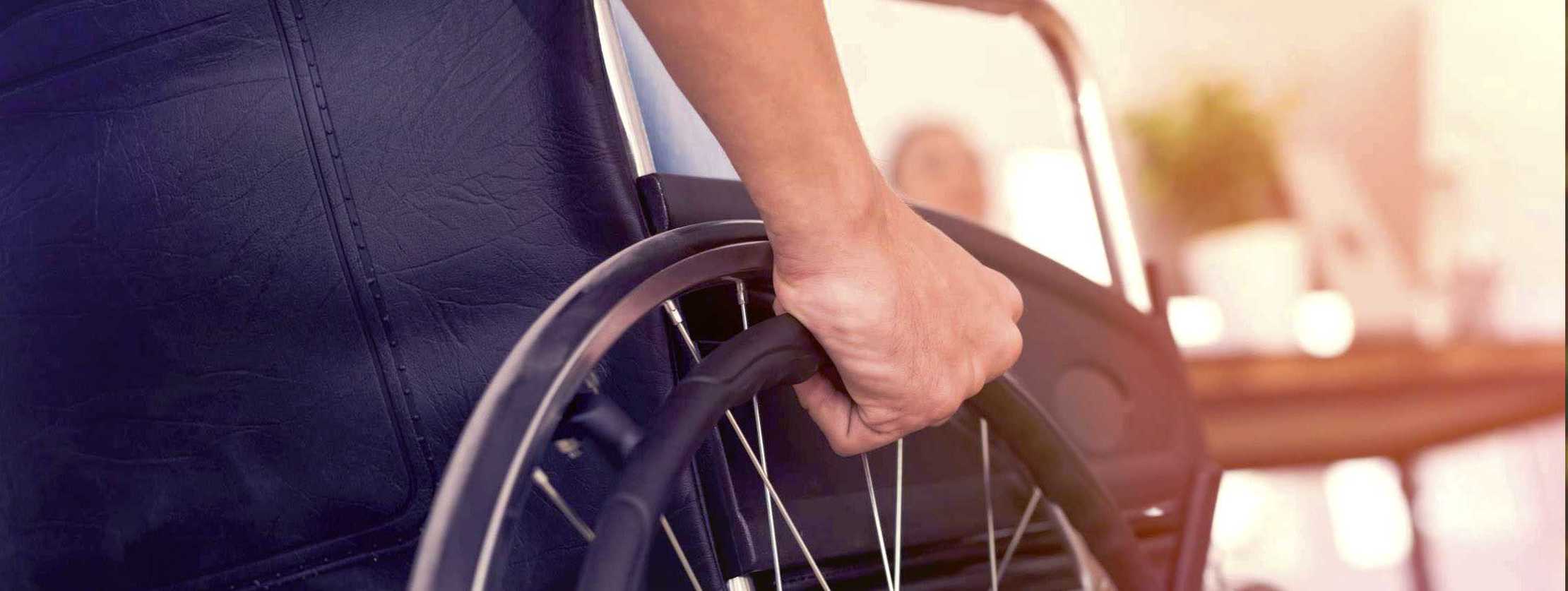 MS und ich: Ein Mann im Rollstuhl mit der rechten Hand am Rad MS und ich: Ein Mann im Rollstuhl mit der rechten Hand am Rad