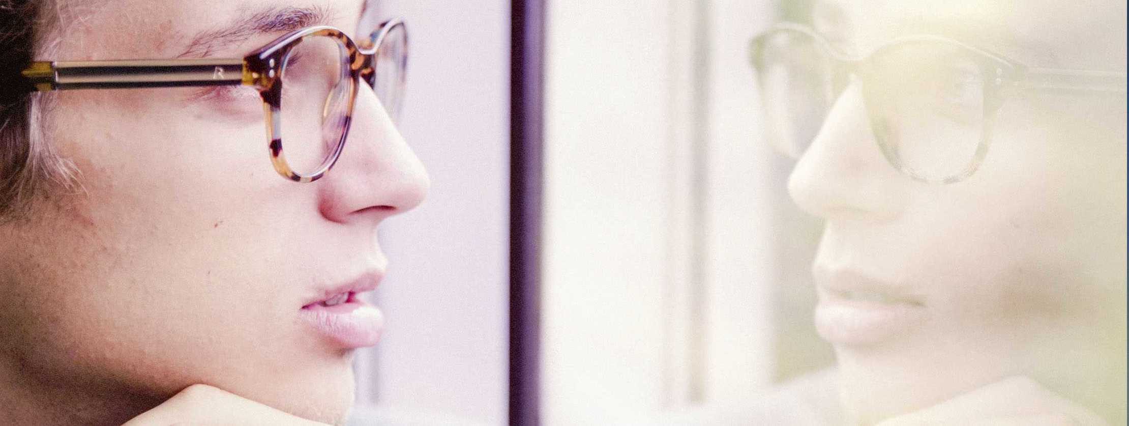 MS und ich: Eine nachdenkliche Frau spiegelt sich in einem Fensterglas MS und ich: Eine nachdenkliche Frau spiegelt sich in einem Fensterglas