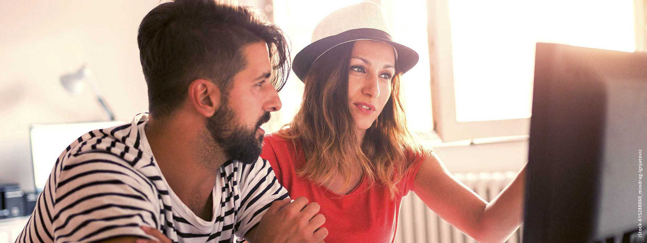 MS und ich: Eine Frau und ein Mann sitzen vor einem Bildschirm. Von draußen knallt die Sonne rein