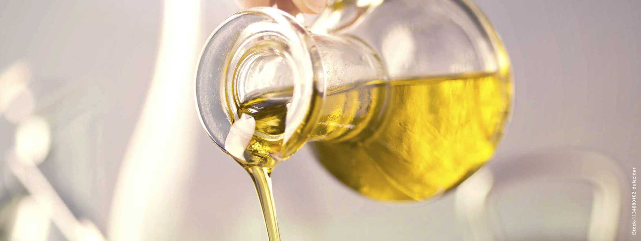 MS und ich: Aus einer kleiner Glaskaraffe fließt Öl in einen Topf