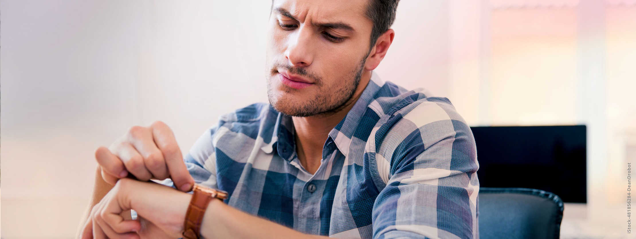 Multiple Sklerose: Ein Mann schaut auf seine Armbanduhr