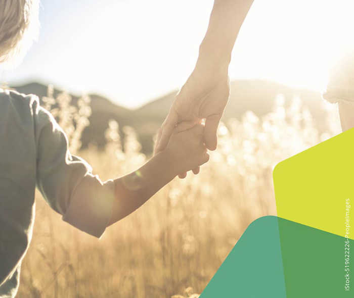 Das Artikelbild zeigt ein Kind, das an der Hand einer Person geht 