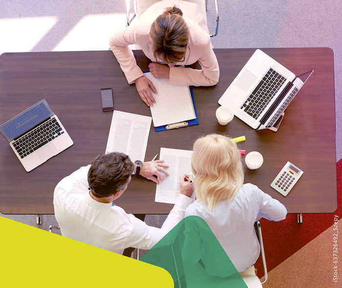 MS und ich: Das Foto von oben zeigt zwei Frauen und einen Mann an einem Konferrenztisch arbeiten