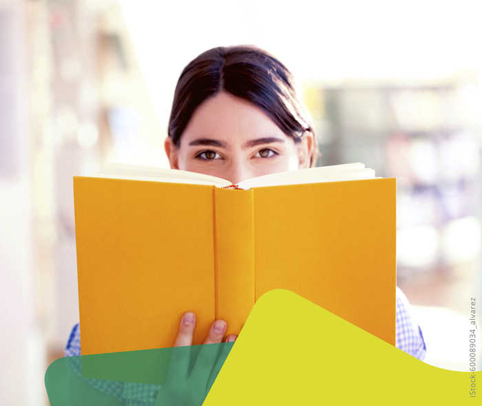 MS und ich: Ein Frau schaut über den Rand eines aufgeklappten Buches in die Kamera