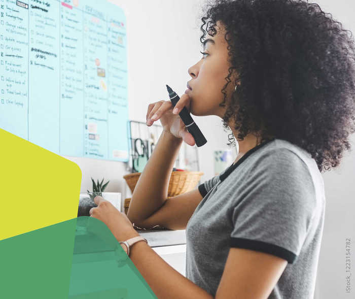 Das Bild zeigt eine Frau, die etwas in ihren Kalender einträgt