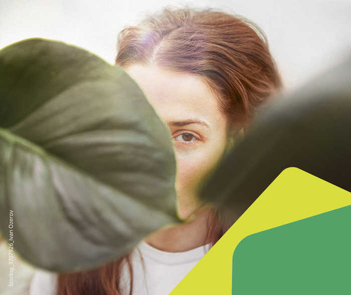 Ein Gesicht hinter einem Blatt