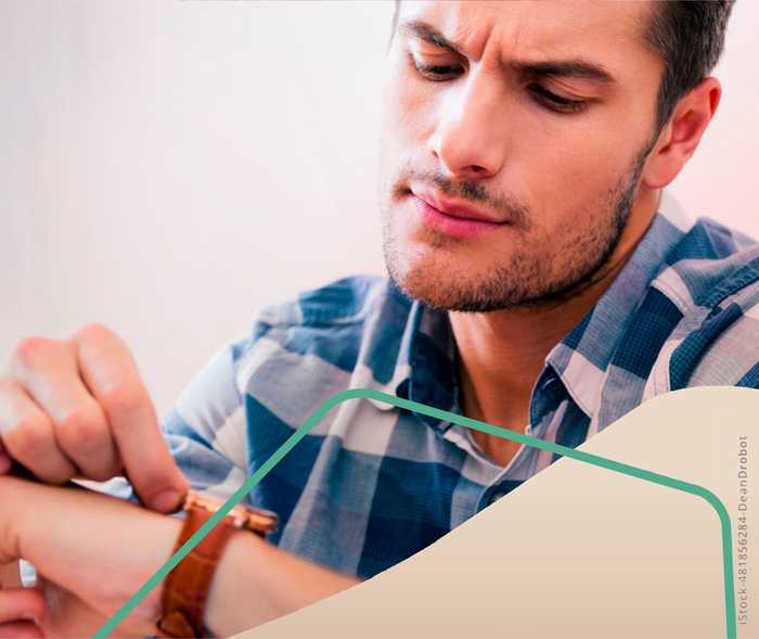 Multiple Sklerose: Ein Mann schaut auf seine Armbanduhr