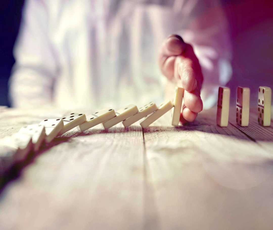 MS und ich: Symptome, kognitive Störungen – eine Hand unterbricht eine Reihe umkippender Dominosteine
