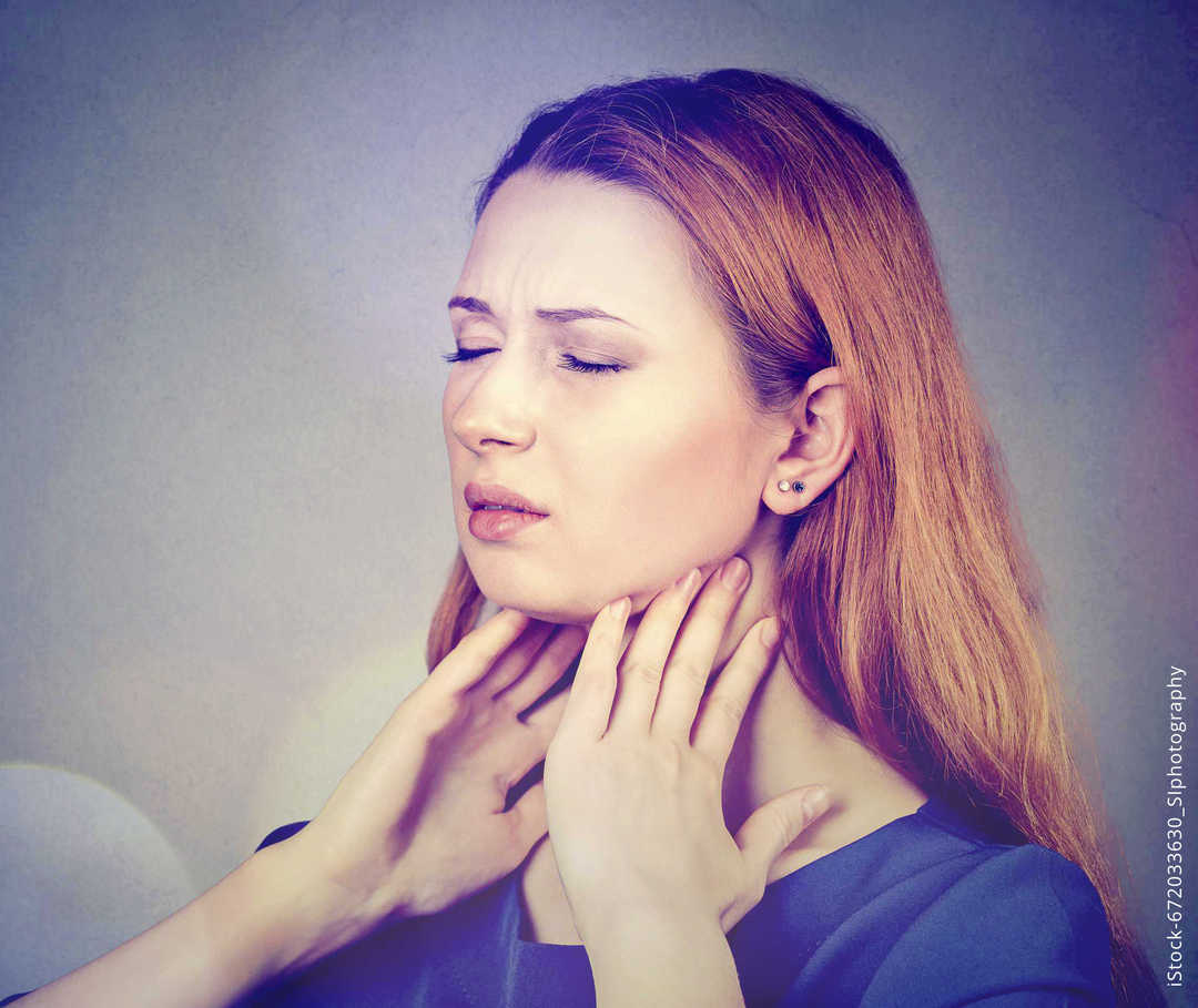 MS und ich: Eine Frau fasst sich mit beiden Händen an den Hals