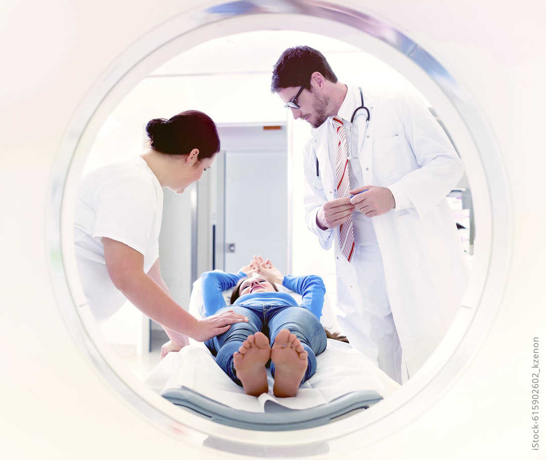 MS und ich: Eine Patientin wird von zwei Medizinern auf ein MRT vorbereitet