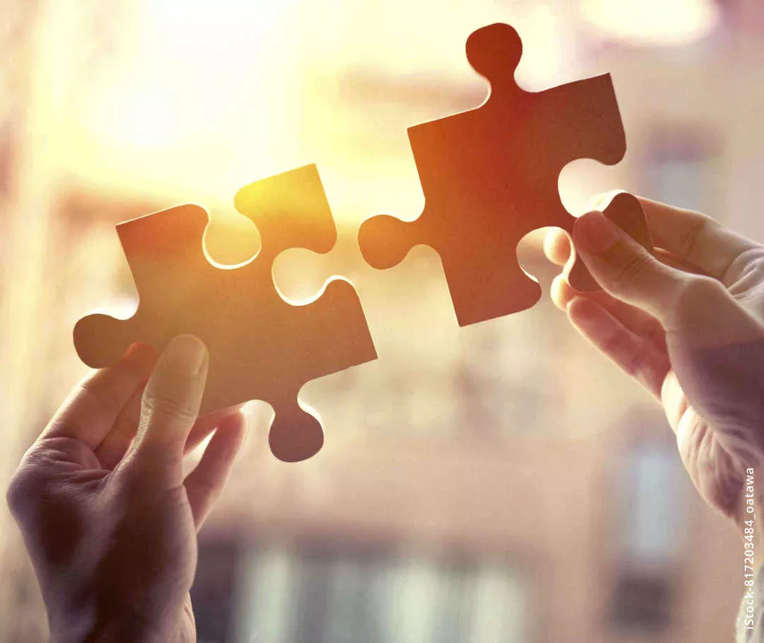 MS und ich: Zwei Hände führen überdimensionale Puzzleteile zusammen