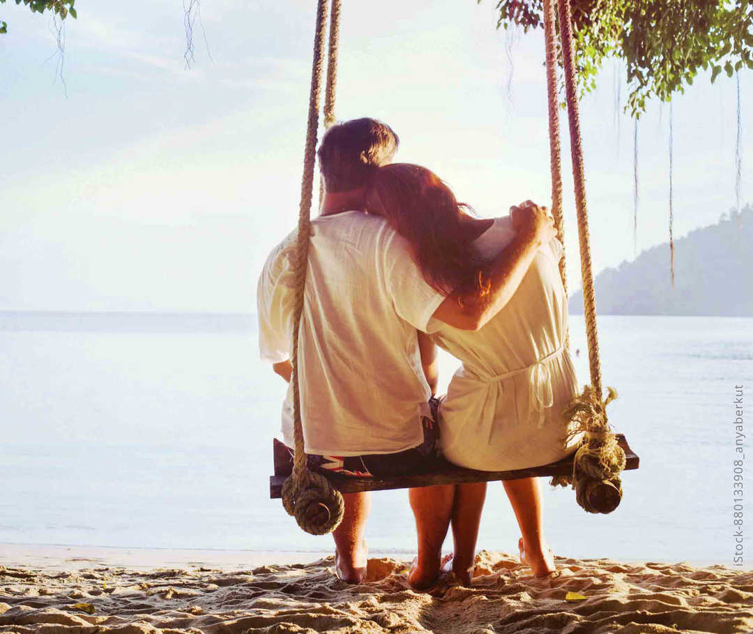 MS und ich: Ein Paar sitzt auf einer Schaukel am Starnd und genießt die Zweisamkeit