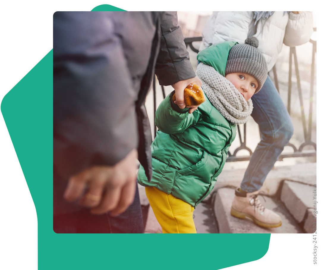 Ein Kleinkind an den Händen seiner Eltern