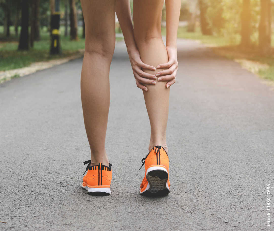 MS &  ich: Eine Joggerin hält sich die rechte Wade