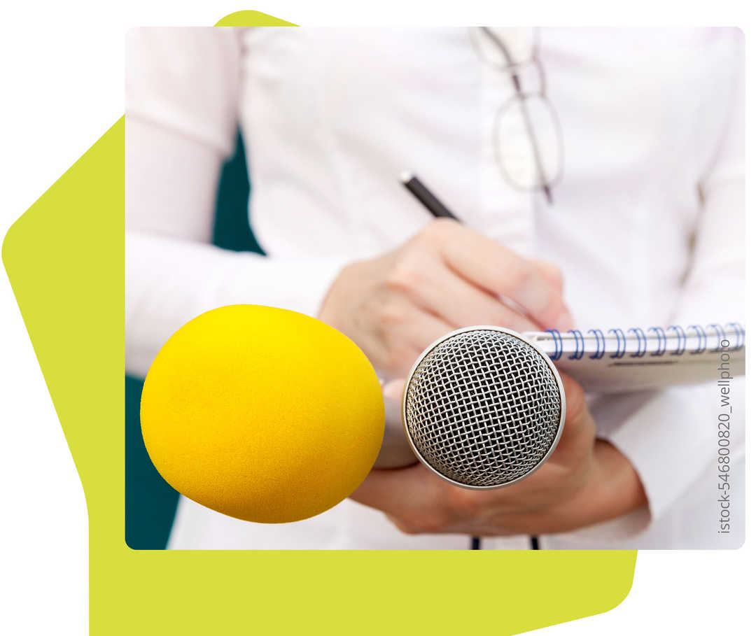 Auf dem Bild sind Hände zu sehen, mit denen Mikrofone und ein Notizbuch gehalten werden