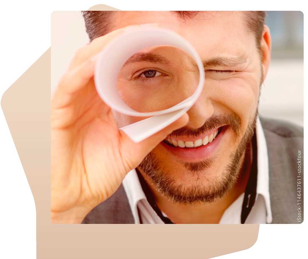 Mann schaut durch eine Papierrolle